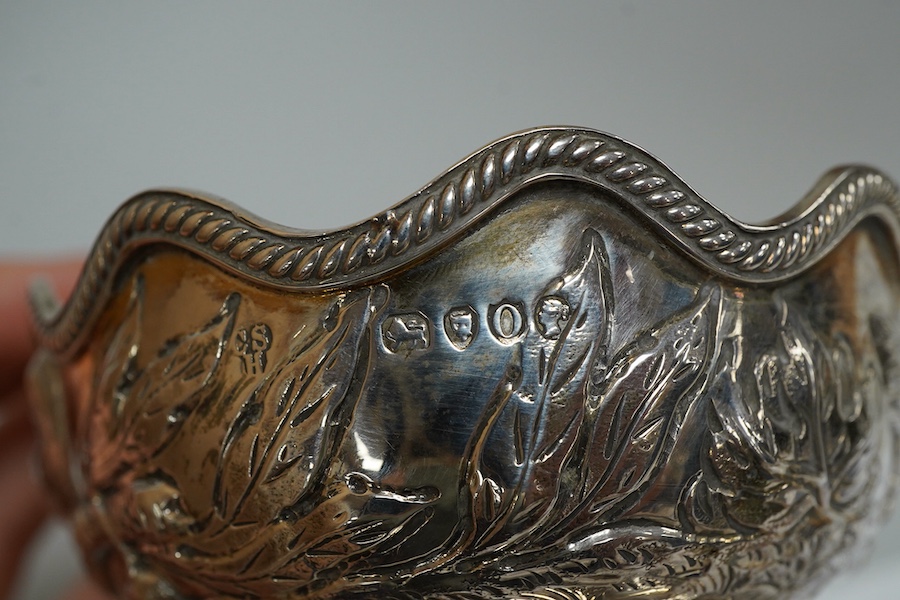 A late Victorian embossed silver oval bowl, decorated with birds, fruit and foliage, Charles Stuart Harris, London, 1889, length 14.3cm, 5.6oz.